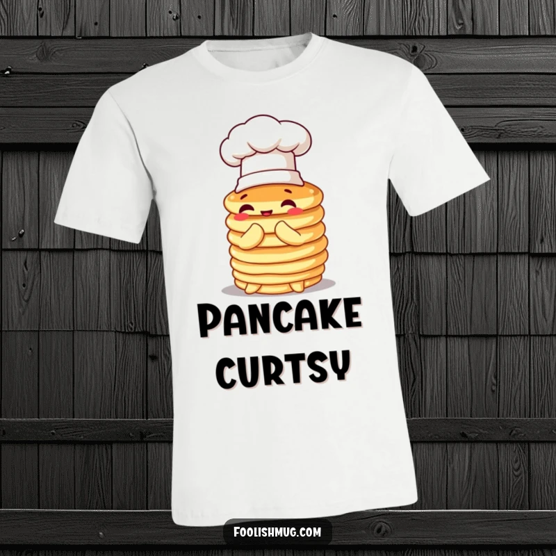 Funny pancake t-shirt, a wobbly stack in a chef hat, comically attempting to bow, expressing humorous culinary charm.