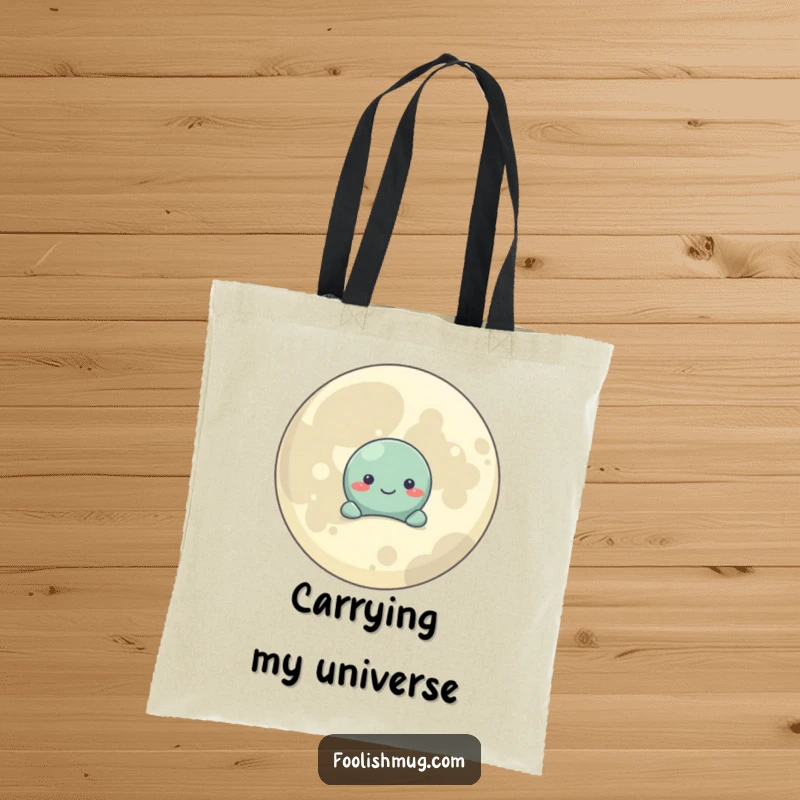 Funny Tote Bag: A shy planet character peeks from behind a smiling moon, perfect for carrying essentials with cosmic flair.